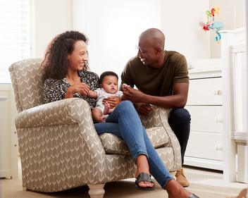 Two adults with a baby in a nursery