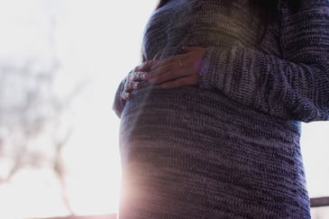 Pregnant woman with hands on her stomach