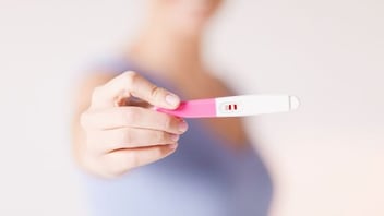 woman holding pregnancy test.